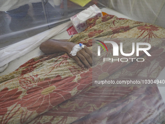 A dengue-infected patient lays down with a blanket stay under mosquito at Shaheed Suhrawardy Medical College and Hospital in Dhaka, Banglade...