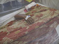 A dengue-infected patient lays down with a blanket stay under mosquito at Shaheed Suhrawardy Medical College and Hospital in Dhaka, Banglade...