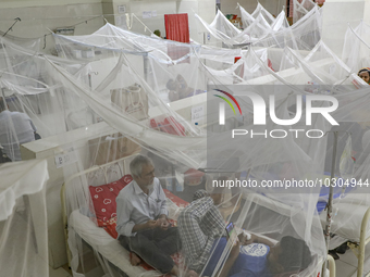 Dengue-infected patients stay under mosquito nets as they receive treatment at the Shaheed Suhrawardy Medical College and Hospital in Dhaka,...