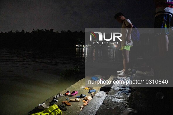 A man looks at the belongings of the passengers of the capsized boat in Laguna Lake that killed more than 20 people, in Binangonan, Rizal Pr...