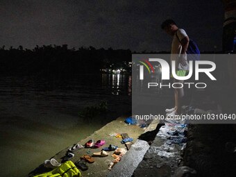 A man looks at the belongings of the passengers of the capsized boat in Laguna Lake that killed more than 20 people, in Binangonan, Rizal Pr...