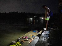 A man looks at the belongings of the passengers of the capsized boat in Laguna Lake that killed more than 20 people, in Binangonan, Rizal Pr...