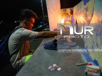 A man lights a candle at the port where a boat capsized, killing more than 20 people, in Laguna Lake, Binangonan, Rizal Province, Philippine...