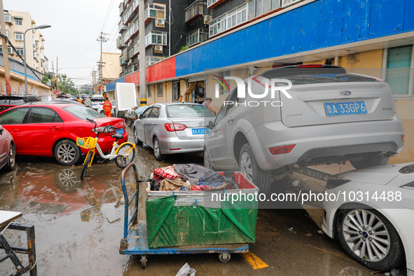 Cars blown over after Super Typhoon Doksuri torrential rain in a community in Jinan, East China's Shandong Province, July 29, 2023. 