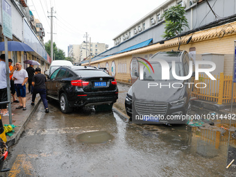 Cars blown over after Super Typhoon Doksuri torrential rain in a community in Jinan, East China's Shandong Province, July 29, 2023. (