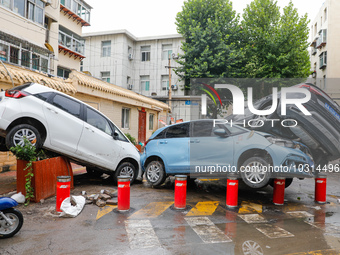 Cars blown over after Super Typhoon Doksuri torrential rain in a community in Jinan, East China's Shandong Province, July 29, 2023. (