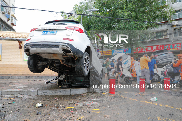 Cars blown over after Super Typhoon Doksuri torrential rain in a community in Jinan, East China's Shandong Province, July 29, 2023. 