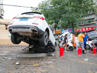 Cars blown over after Super Typhoon Doksuri torrential rain in a community in Jinan, East China's Shandong Province, July 29, 2023. (