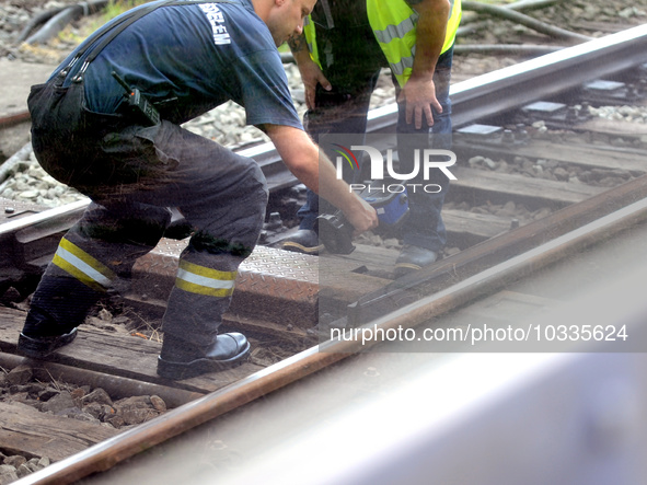 A firmean checks the temperature of the rails after the tracks smoked in the Budapest Metro , on august 04, 2023. 