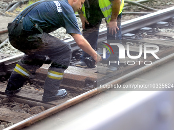 A firmean checks the temperature of the rails after the tracks smoked in the Budapest Metro , on august 04, 2023. (