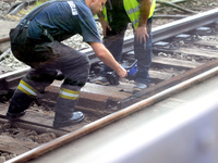 A firmean checks the temperature of the rails after the tracks smoked in the Budapest Metro , on august 04, 2023. (