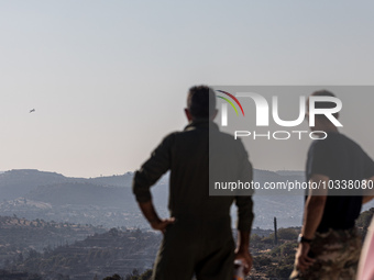 Two men of the Fire Department watch a plane patrolling the area, Alassa, Cyprus, on Aug. 5, 2023. Fire Department and Forest Department uni...