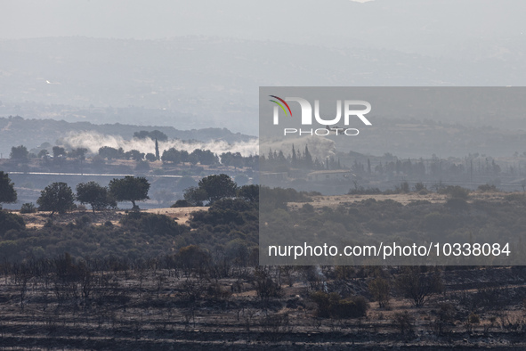 A plane throws water over a smoking area to prevent the fire break out again, Alassa, Cyprus, on Aug. 5, 2023. Fire Department and Forest De...