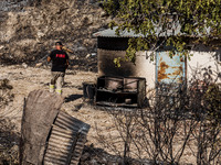 A fireman inspects the area around a semi-burnt shed, Alassa, Cyprus, on Aug. 5, 2023. Fire Department and Forest Department units, patrol t...