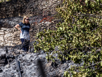 A woman that lives near the burnt area, inspects the surroundings, Alassa, Cyprus, on Aug. 5, 2023. Fire Department and Forest Department un...