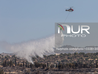 A helicopter of the Jordanian Fire Department throws water over the burnt area, Alassa, Cyprus, on Aug. 5, 2023. Jordan helps with two helic...