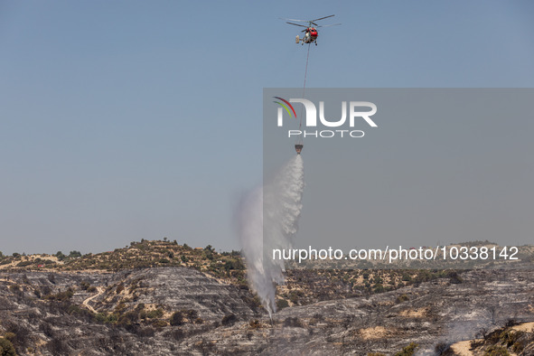 A helicopter of the Jordanian Fire Department throws water over the burnt area, Alassa, Cyprus, on Aug. 5, 2023. Jordan helps with two helic...