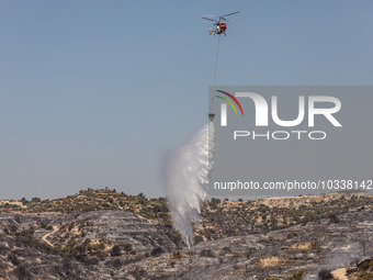 A helicopter of the Jordanian Fire Department throws water over the burnt area, Alassa, Cyprus, on Aug. 5, 2023. Jordan helps with two helic...