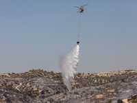 A helicopter of the Jordanian Fire Department throws water over the burnt area, Alassa, Cyprus, on Aug. 5, 2023. Jordan helps with two helic...