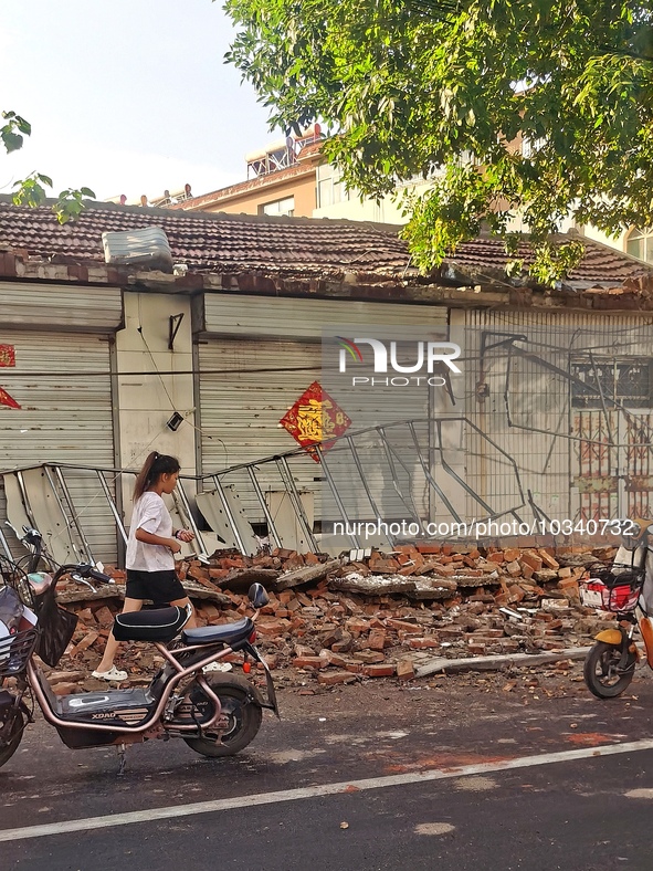 DEZHOU, CHINA - AUGUST 6, 2023 - A citizen passes a collapsed house after an earthquake in an urban area of Pingyuan County, in Dezhou, Shan...