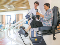  An elderly man is escorted by medical staff during rehabilitation training at the ''Rehabilitation Home'', a community health service cente...