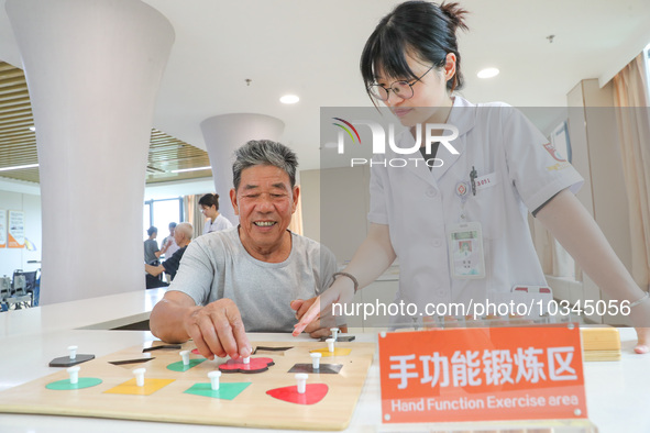  An elderly man is escorted by medical staff during rehabilitation training at the ''Rehabilitation Home'', a community health service cente...