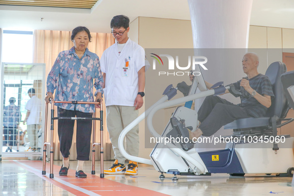  An elderly man is escorted by medical staff during rehabilitation training at the ''Rehabilitation Home'', a community health service cente...