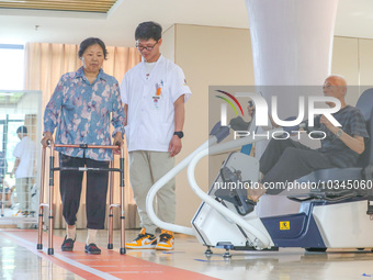  An elderly man is escorted by medical staff during rehabilitation training at the ''Rehabilitation Home'', a community health service cente...