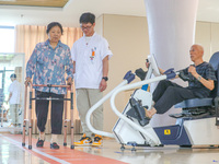  An elderly man is escorted by medical staff during rehabilitation training at the ''Rehabilitation Home'', a community health service cente...