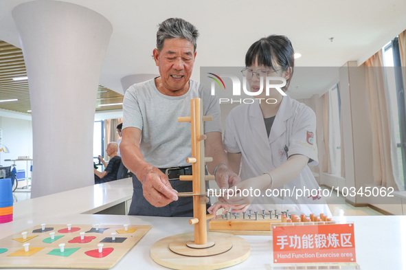  An elderly man is escorted by medical staff during rehabilitation training at the ''Rehabilitation Home'', a community health service cente...