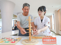  An elderly man is escorted by medical staff during rehabilitation training at the ''Rehabilitation Home'', a community health service cente...