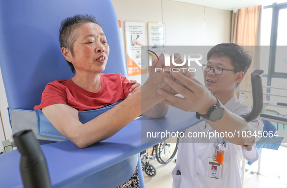  An elderly man is escorted by medical staff during rehabilitation training at the ''Rehabilitation Home'', a community health service cente...