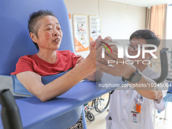  An elderly man is escorted by medical staff during rehabilitation training at the ''Rehabilitation Home'', a community health service cente...