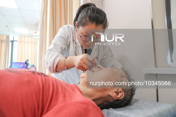  A medical worker performs acupuncture for an elderly person at the ''Rehabilitation Home'', a community health service center in Deqing cou...