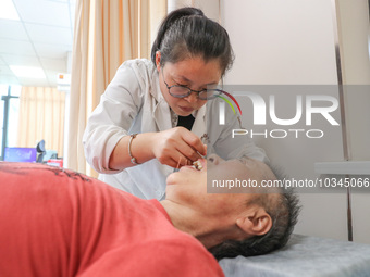  A medical worker performs acupuncture for an elderly person at the ''Rehabilitation Home'', a community health service center in Deqing cou...