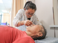  A medical worker performs acupuncture for an elderly person at the ''Rehabilitation Home'', a community health service center in Deqing cou...