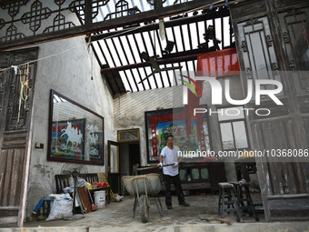 A citizen cleans up a damaged house after a tornado in Dafeng district, Yancheng city, Jiangsu province, China, August 14, 2023. It is under...