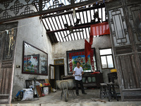 A citizen cleans up a damaged house after a tornado in Dafeng district, Yancheng city, Jiangsu province, China, August 14, 2023. It is under...