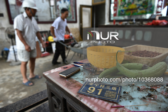 A citizen cleans up a damaged house after a tornado in Dafeng district, Yancheng city, Jiangsu province, China, August 14, 2023. It is under...