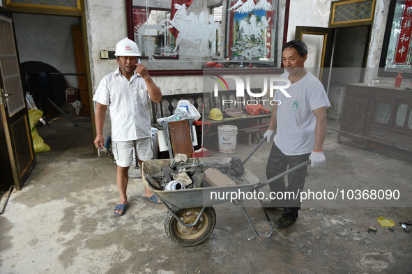 A citizen cleans up a damaged house after a tornado in Dafeng district, Yancheng city, Jiangsu province, China, August 14, 2023. It is under...