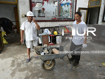 A citizen cleans up a damaged house after a tornado in Dafeng district, Yancheng city, Jiangsu province, China, August 14, 2023. It is under...