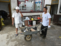 A citizen cleans up a damaged house after a tornado in Dafeng district, Yancheng city, Jiangsu province, China, August 14, 2023. It is under...