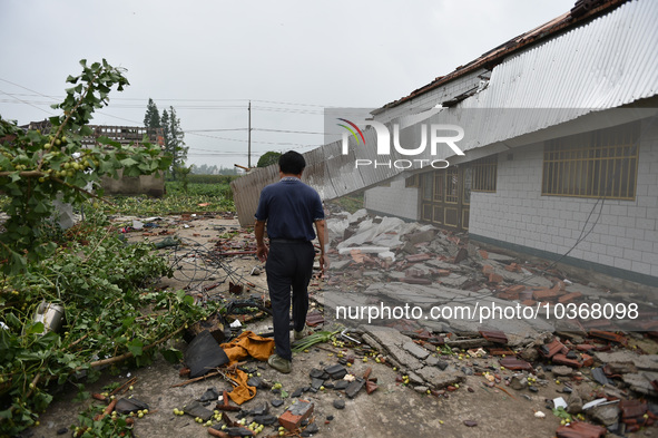 A citizen passes a damaged house after a tornado in Dafeng district, Yancheng city, Jiangsu province, China, August 14, 2023. It is understo...