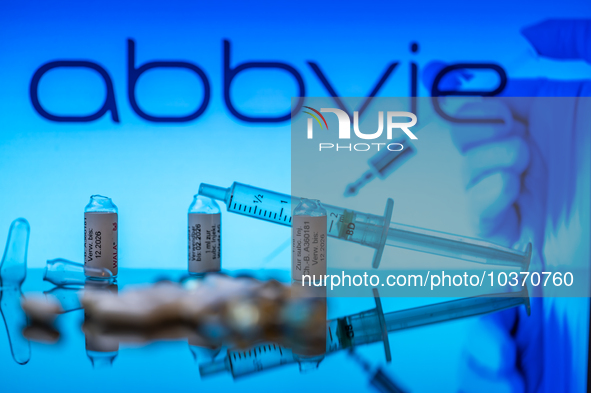 Abbvie Pharma logo seen on screen in the background with pills and medical vial with syringe, seen in this photo illustration, on 14 August...