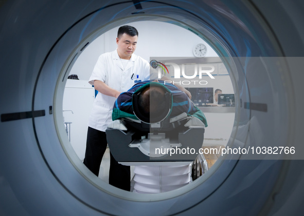 Radiologist Cheng Lu assists a patient with a CT examination in Chongqing, China, August 18, 2023. August 19 is the Chinese Doctor's Day. 