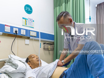 Gastroenterologist Tian Chuanzai examines a patient in Chongqing, China, August 18, 2023. August 19th is the Chinese Doctor's Day. (