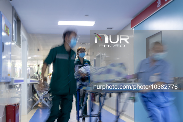 Emergency department doctor Luo Pengyu (left) escorts an emergency patient into the emergency room in Chongqing, China, August 18, 2023. Aug...