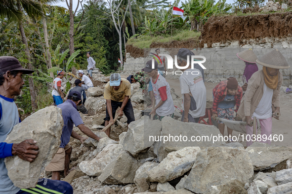 Villagers, including men and women, work together (gotong royong) to renovate a broken village road at Kebumen, Central Java, Indonesia on A...