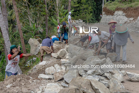 Villagers, including men and women, work together (gotong royong) to renovate a broken village road at Kebumen, Central Java, Indonesia on A...