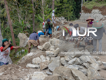 Villagers, including men and women, work together (gotong royong) to renovate a broken village road at Kebumen, Central Java, Indonesia on A...